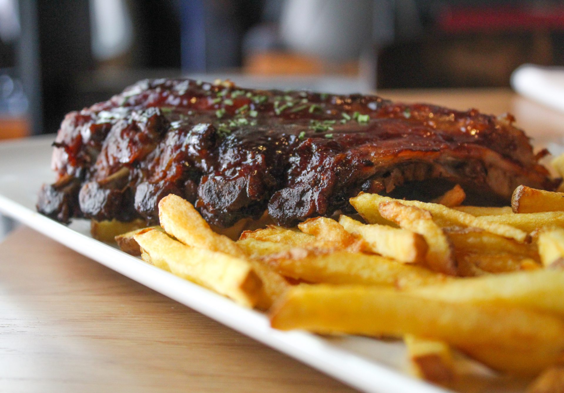 Costillas de cerdo BBQ con patatas fritas rústicas.