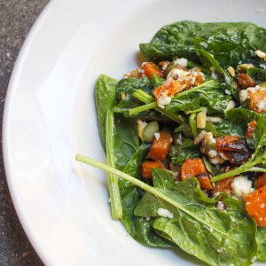 Ensalada de espinacas, calabaza asada, queso feta y pipas.