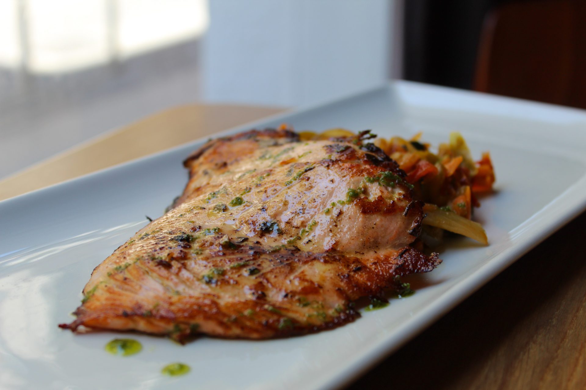 Salmón asado con cilantro y lima, sobre cama de verduras