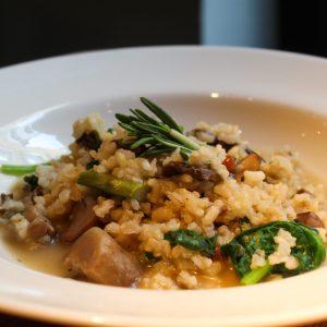 Arroz integral caldoso, con trigueros, setas de otoño y espinacas