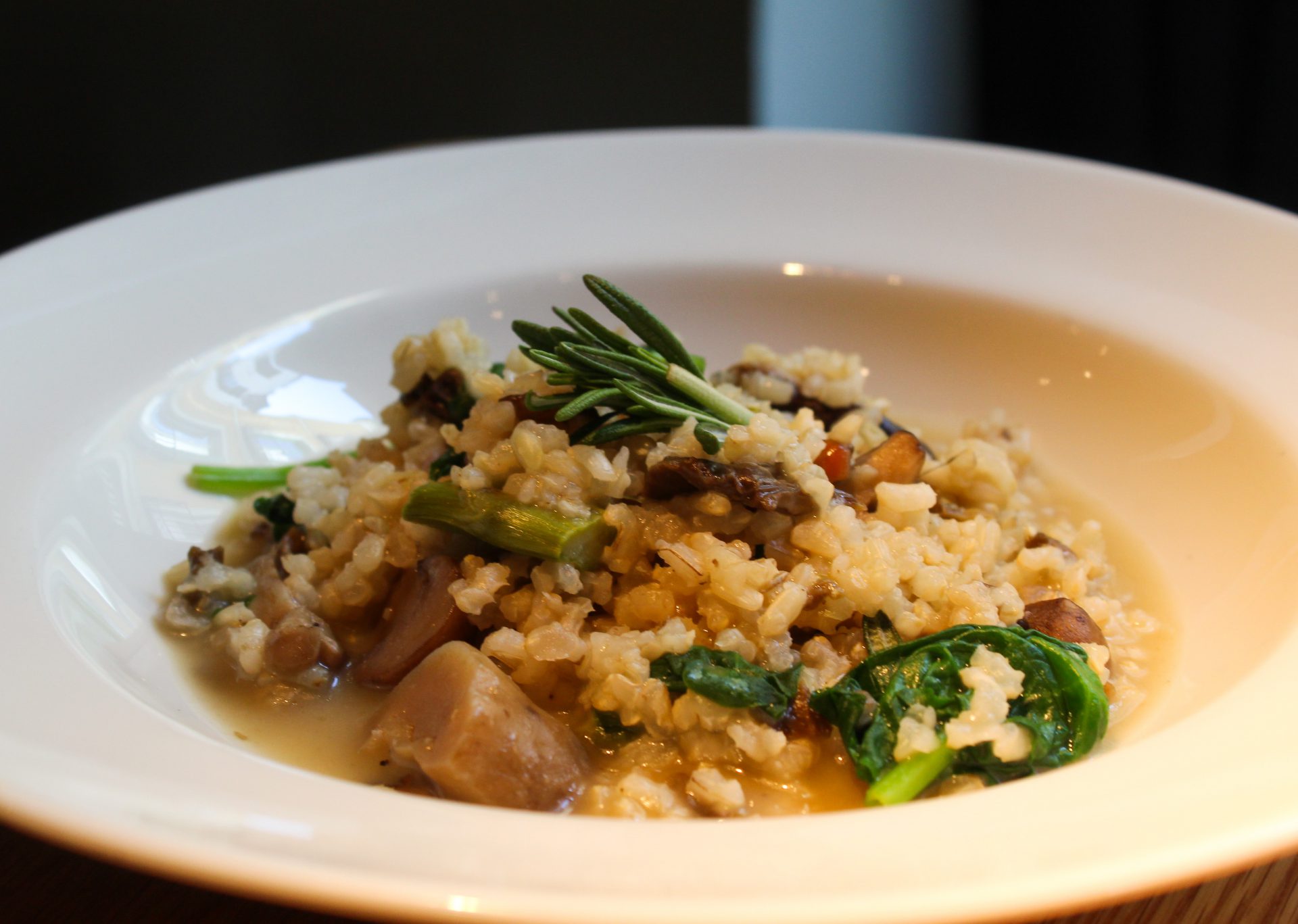 Arroz integral caldoso, con trigueros, setas de otoño y espinacas