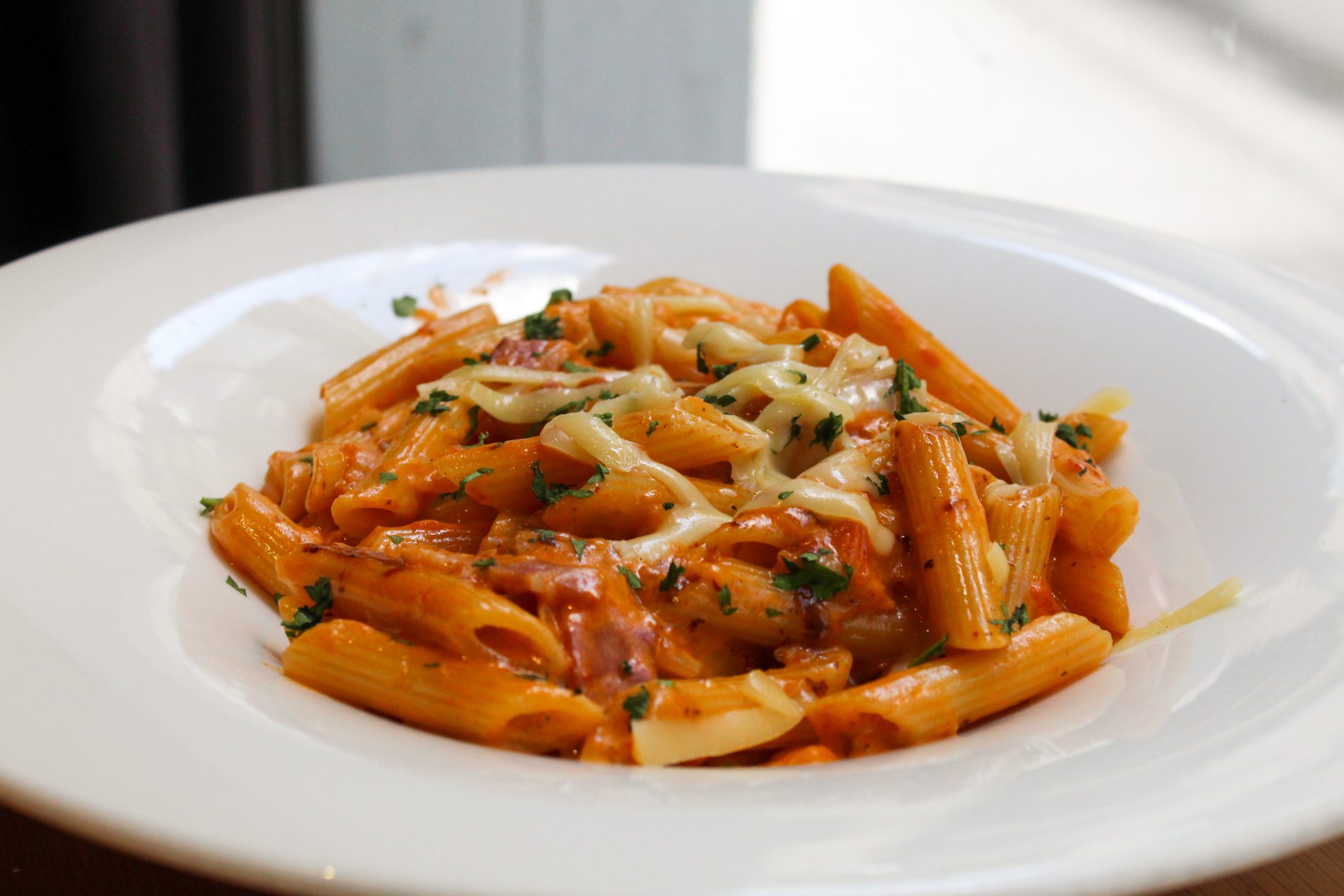 Penne rigatte a la Amatriciana con bacon, salsa de tomate casera, nata, una pizca de Cayena y parmesano rallado